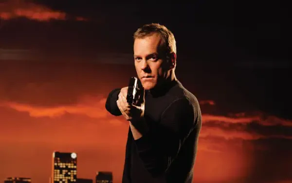 HD PC desktop wallpaper/background (tagged 24): intense man in black aiming a handgun toward the viewer, orange-red sky and silhouetted city skyline behind him.