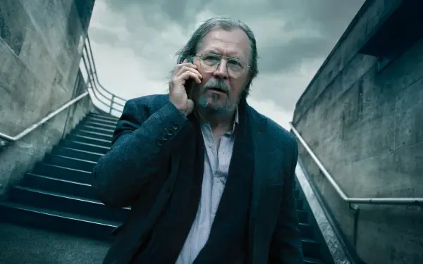 Gritty portrait of a disheveled older man on concrete stairs, speaking on a phone — Slow Horses 4K Ultra HD PC desktop wallpaper and background.