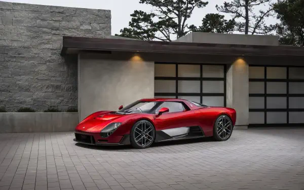 Red McLaren McL 6GT sports supercar parked in front of a modern garage; 8K Ultra HD PC desktop wallpaper and background.
