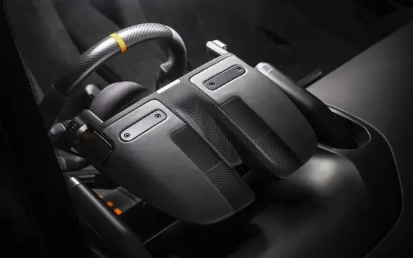 Close-up of McLaren McL 6GT vehicle controller-style center console in 8K Ultra HD PC desktop wallpaper, showing carbon-fiber paddles and ergonomic controls.