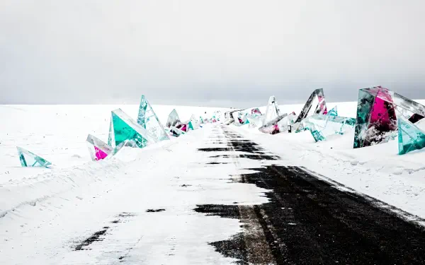 4K Ultra HD PC desktop wallpaper and background: snowy winter road and path through white fields, dark tire tracks leading past colorful crystalline shards jutting from the snow.