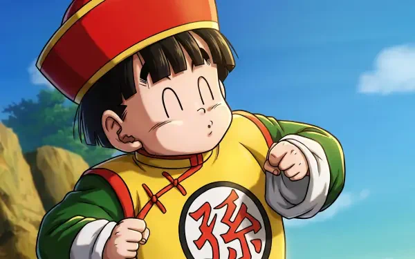 HD PC desktop wallpaper: Dragon Ball Z anime of Gohan (Dragon Ball) as a child in a yellow-green traditional outfit and red hat, smiling against a bright blue sky and rocky hillside.