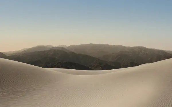 Minimal 4K Ultra HD PC desktop wallpaper: smooth desert dunes in foreground with layered mountain ridges under a soft gradient sky, tagged iPhone Duo and computer.