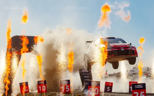 Toyota Gazoo Racing GR Yaris Rally1 airborne amid flames and sparks in a WRC scene, 4K Ultra HD desktop wallpaper.