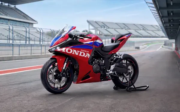 Red and blue Honda CBR500R Four sportbike on a racetrack, featured in a 5K Ultra HD PC desktop wallpaper background.