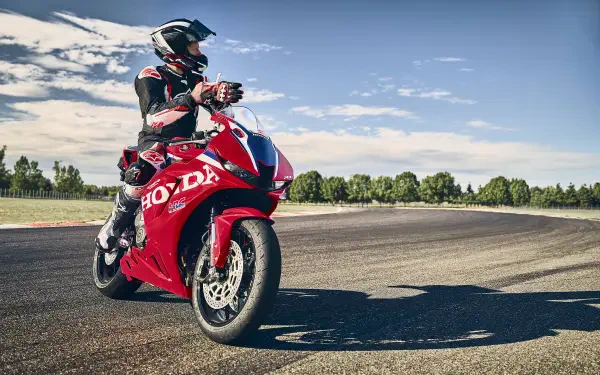 Motorcyclist on a red Honda CBR600RR at a racetrack, 5K Ultra HD PC desktop wallpaper and background.