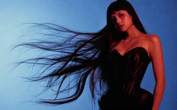 LISA of BLACKPINK in a black outfit with flowing hair against a blue backdrop, 4K Ultra HD desktop wallpaper