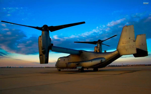 HD desktop wallpaper featuring a Bell Boeing V-22 Osprey military aircraft on a runway against a vibrant sunset sky.
