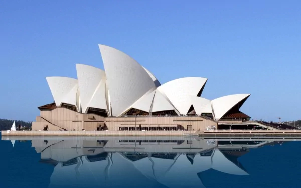 HD desktop wallpaper showcasing the iconic Sydney Opera House, a striking man-made architectural landmark against a clear blue sky and calm water reflection.