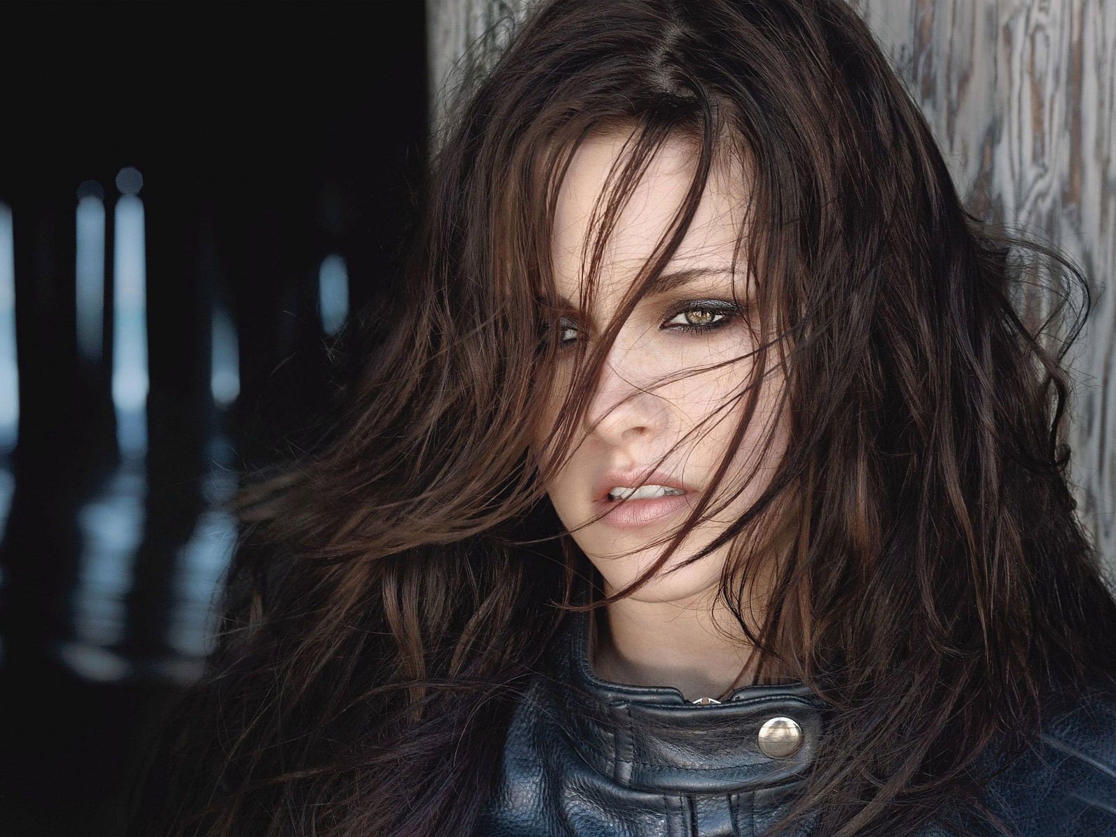 HD PC desktop wallpaper featuring a close-up of celebrity Kristen Stewart with tousled hair and an intense gaze against a blurred dark background.