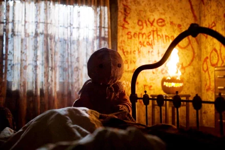 HD PC desktop wallpaper featuring a scene from the movie Trick 'r Treat, showing the iconic character Sam sitting on a bed in a dimly lit, eerie room.