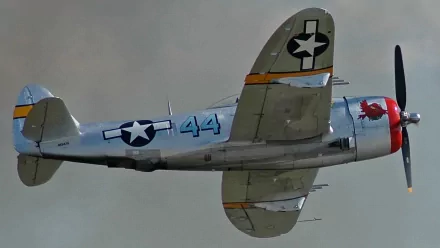 HD PC desktop wallpaper featuring a vintage military aircraft in flight, showcasing detailed markings and a gray-blue sky background.