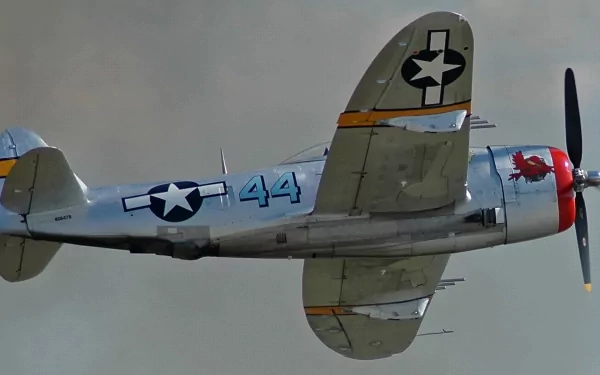 HD PC desktop wallpaper featuring a vintage military aircraft in flight, showcasing detailed markings and a gray-blue sky background.