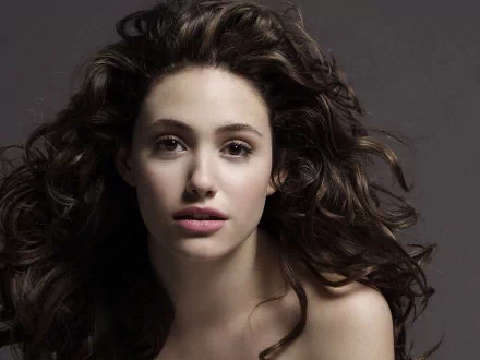 HD PC desktop wallpaper featuring a close-up portrait of celebrity Emmy Rossum with flowing dark hair against a dark background.