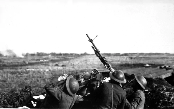 A historical black-and-white image of soldiers operating a machine gun, set against an expansive battlefield backdrop, making an impactful HD desktop wallpaper.