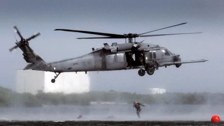 HD PC desktop wallpaper: military Sikorsky HH-60 Pave Hawk hovering low over water as a rescuer descends on a hoist.