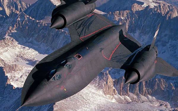 A striking HD image of the Lockheed SR-71 Blackbird soaring over mountain ranges, showcasing its sleek design as a pioneer in military aircraft technology.
