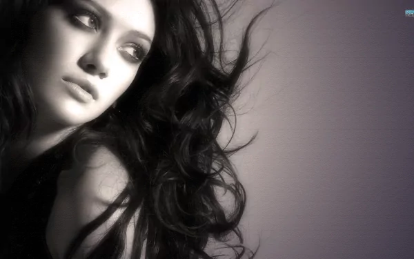HD PC desktop wallpaper featuring a close-up black-and-white portrait of celebrity Hilary Duff with flowing hair and a contemplative expression.