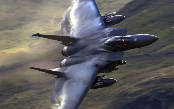HD desktop wallpaper featuring a McDonnell Douglas F-15 Eagle jet in military flight, captured with dynamic motion and atmospheric background.