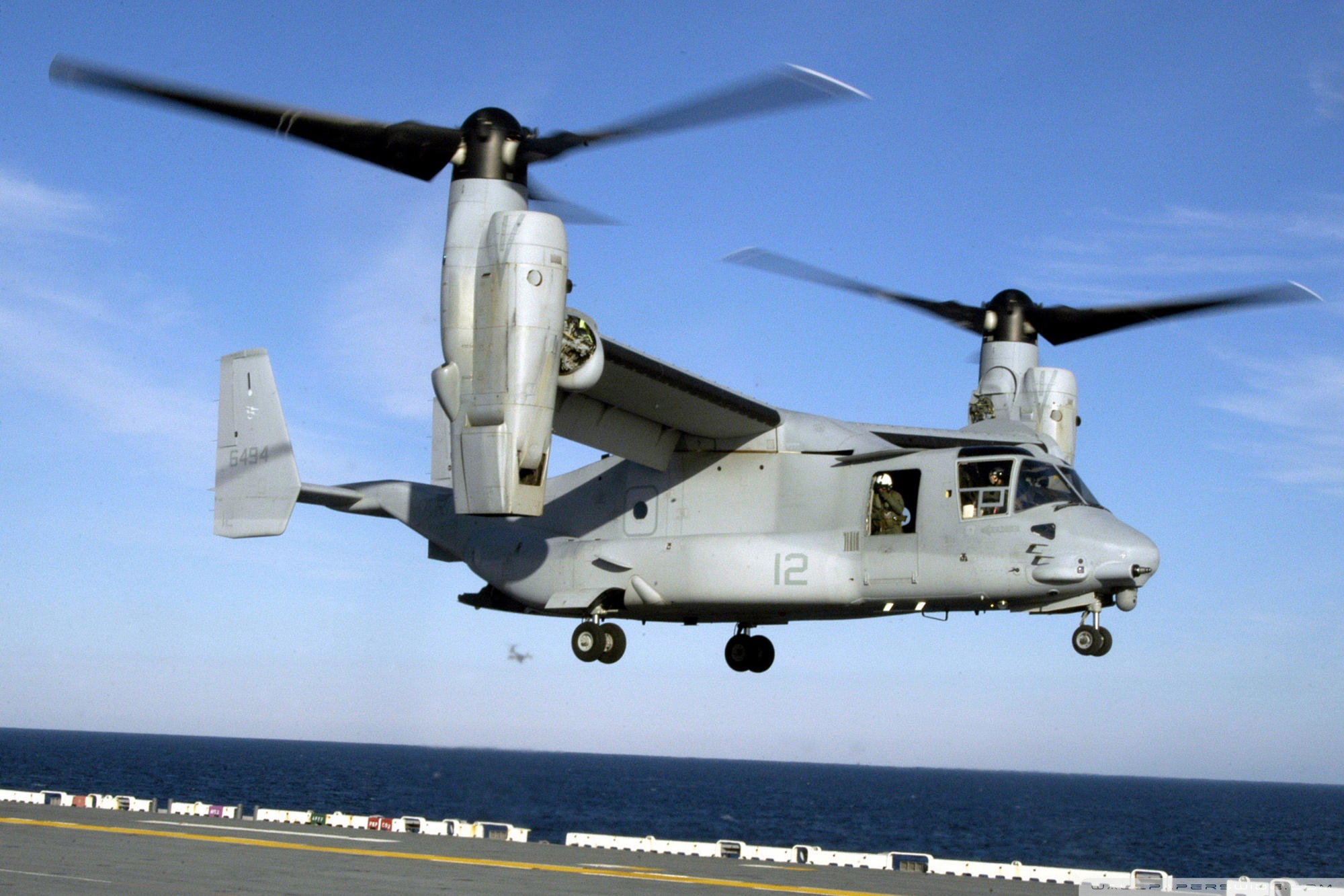 A military aircraft, the Bell Boeing V-22 Osprey, soaring across a vibrant desktop wallpaper.