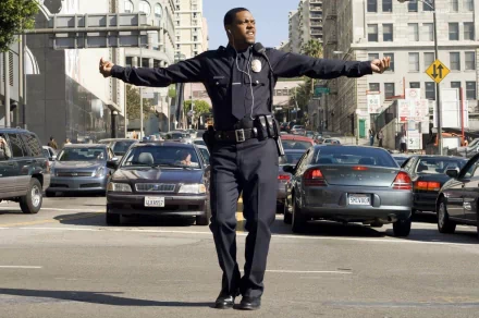 A police officer confidently dances in the middle of a busy street, surrounded by cars, capturing a lively urban scene. This HD wallpaper showcases a moment of joy amidst traffic.