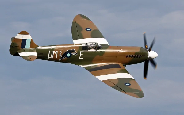 HD desktop wallpaper of a vintage military aircraft flying against a cloudy sky, showcasing its detailed camouflage and markings.