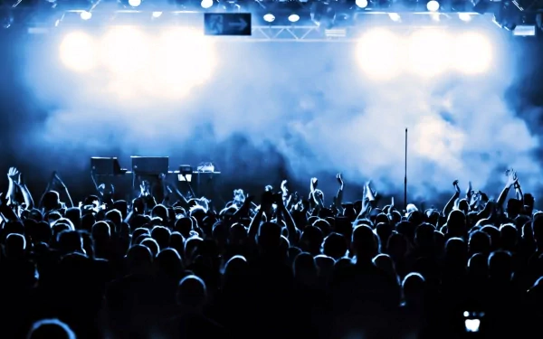 HD desktop wallpaper capturing the energized crowd and bright stage lights at a live concert, highlighting the vibrant atmosphere of music performance.