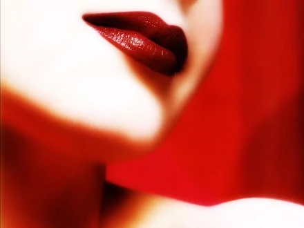 A close-up of a woman's lips adorned with deep red lipstick, set against a vibrant red background, creating a striking HD desktop wallpaper.