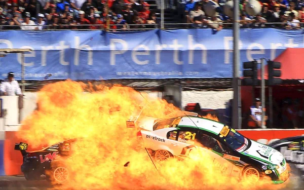 HD PC desktop wallpaper showing a sports car racing through flames at a packed track; vehicle skids amid a dramatic fiery crash.
