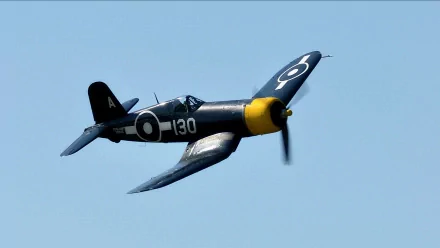 HD desktop wallpaper featuring a military aircraft in flight against a clear blue sky.