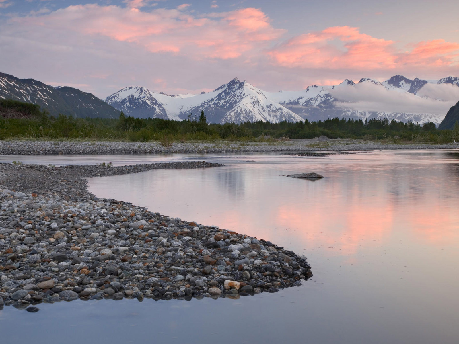 Alsek River sunset in Alaska, with snowy riverbanks.