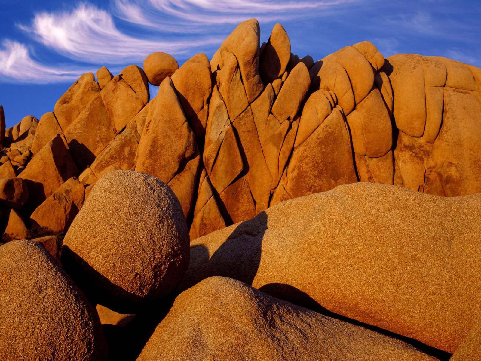 A stunning view of rock formations in Joshua Tree National Park, California, showcasing the unique desert landscape under a clear blue sky.
