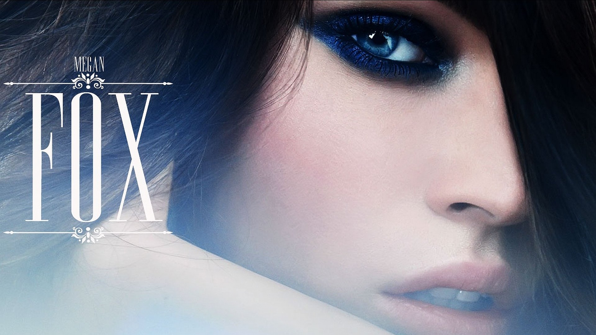 HD PC desktop wallpaper featuring a close-up of celebrity Megan Fox with smoky eye makeup and intense blue eyes.