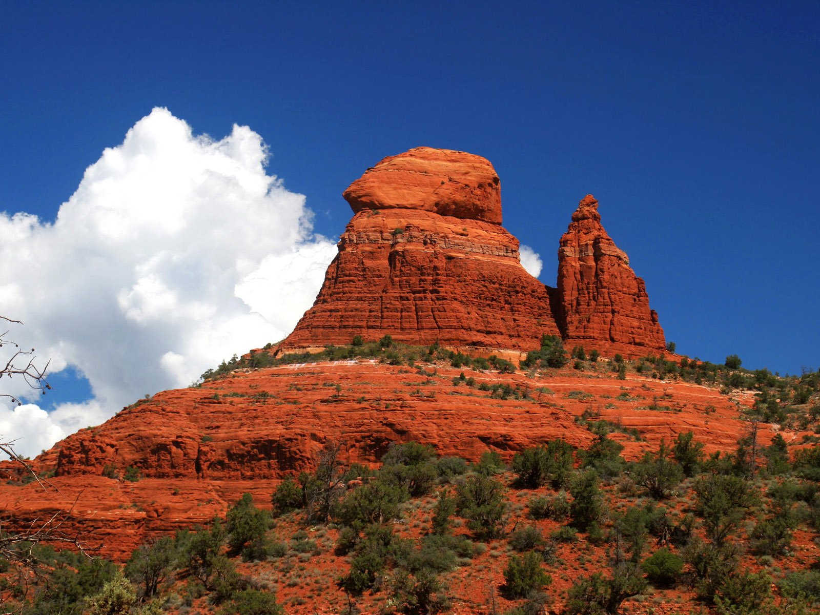 A striking mountain formation rises against a vivid blue sky, adorned with fluffy white clouds, showcasing the beauty of nature in this HD desktop wallpaper.