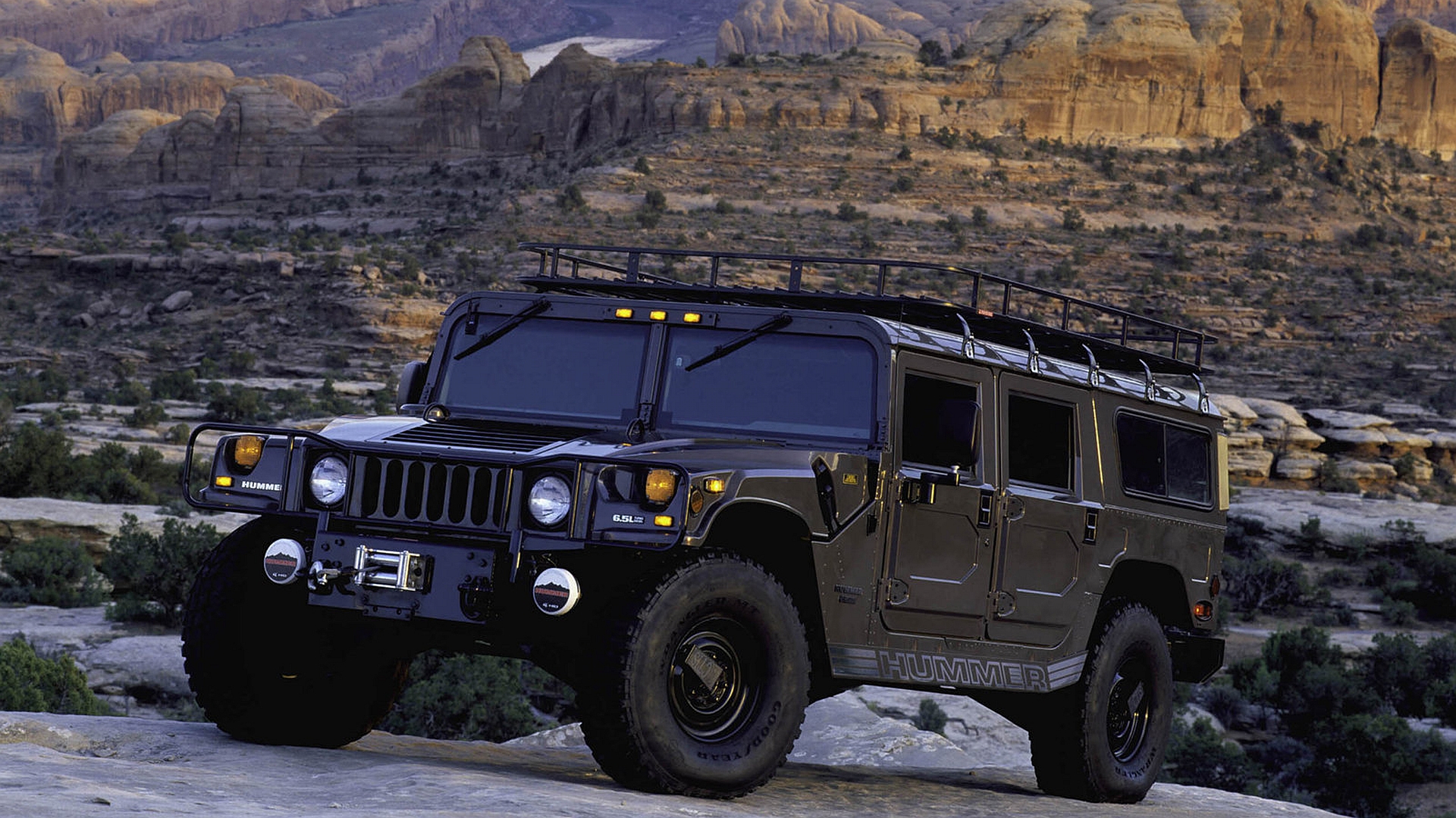 White Hummer driving through a rugged terrain, ready for adventure.