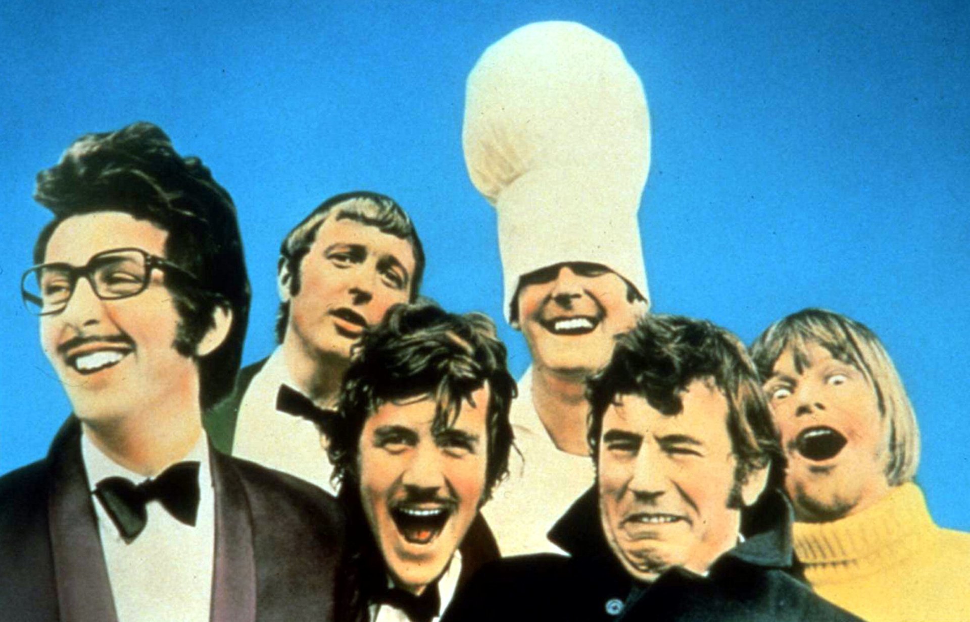 Monty Python's Flying Circus cast in a vibrant HD desktop wallpaper, capturing the iconic TV show's quirky and comedic spirit against a clear blue sky.