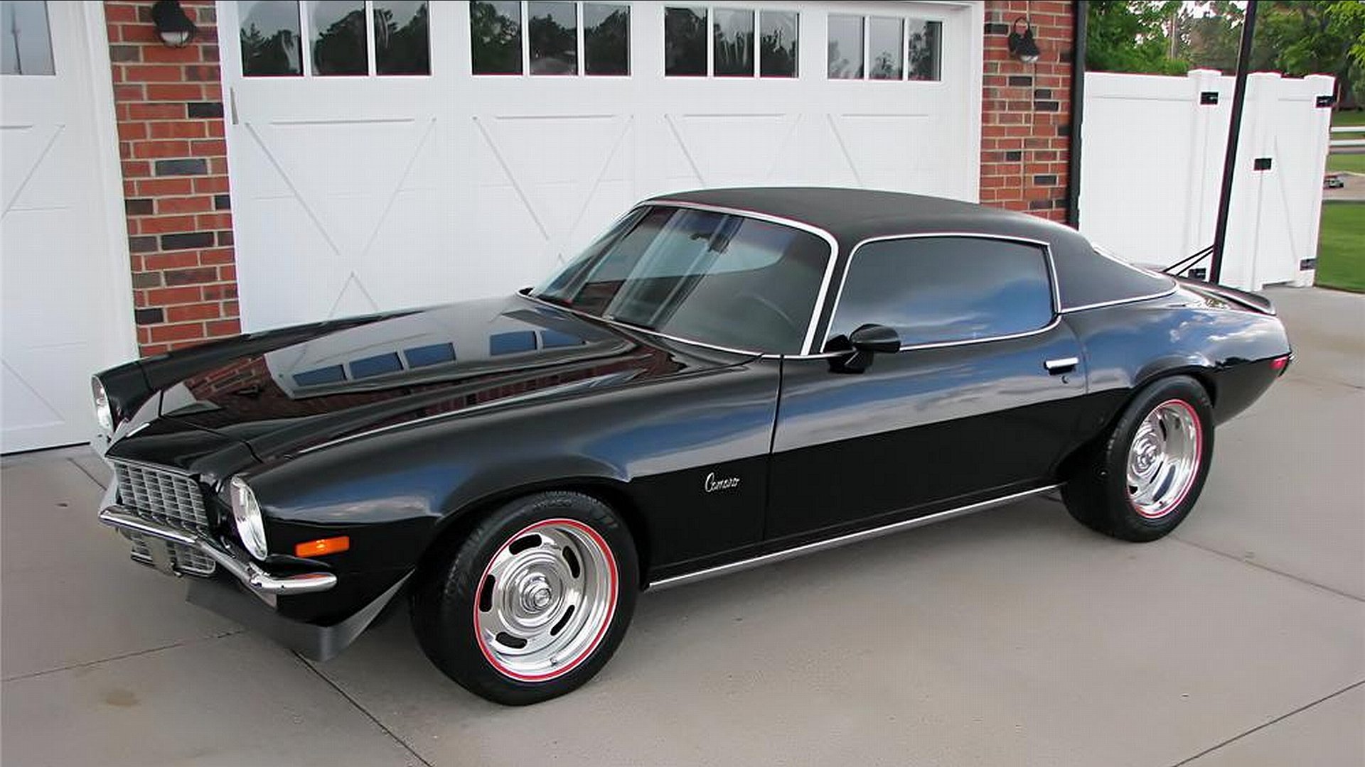 A sleek black Chevrolet Camaro parked in front of a garage, showcased as a 4K Ultra HD PC desktop wallpaper and background.
