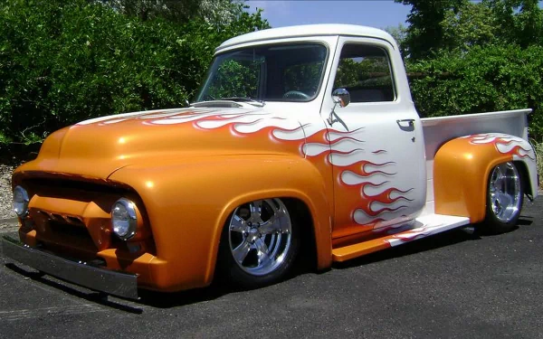 A custom Ford truck with orange and white paint featuring flame decals, showcased in a 4K Ultra HD PC desktop wallpaper and background.