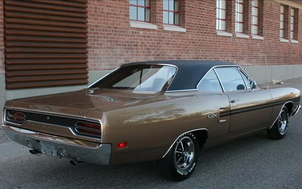 4K Ultra HD PC desktop wallpaper background: bronze Plymouth vehicle parked by a brick wall, shown from a rear three-quarter view.