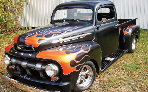 4K Ultra HD PC wallpaper featuring a classic Ford truck with black paint and vibrant orange flame detailing parked on grass near a fence.