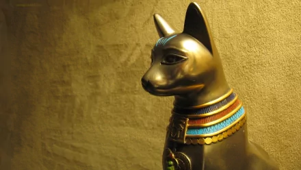 4K Ultra HD PC desktop wallpaper of an Egyptian golden man-made statue: a gilded cat figure with an ornate blue-and-red collar against a textured gold background.