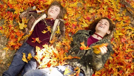 Movie: The Odd Life Of Timothy Green — 4K Ultra HD PC desktop wallpaper/background of two children lying and laughing in bright autumn leaves.