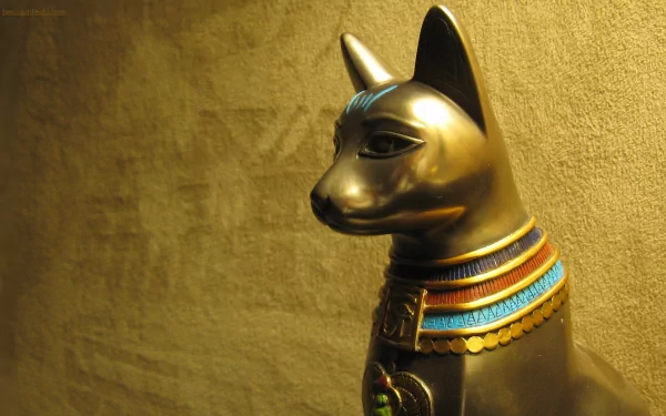 4K Ultra HD PC desktop wallpaper of an Egyptian golden man-made statue: a gilded cat figure with an ornate blue-and-red collar against a textured gold background.