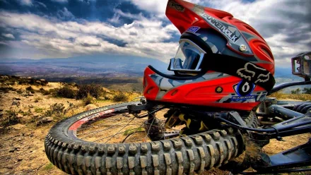 A vibrant BMX helmet rests on a tire against a dramatic sky, showcasing the thrill of sports in this stunning 4K Ultra HD desktop wallpaper.
