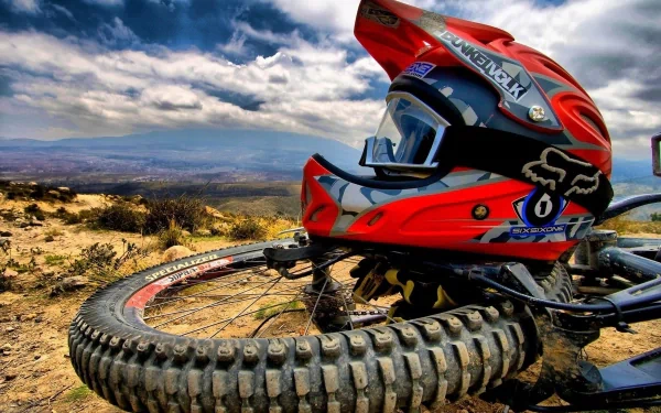 A vibrant BMX helmet rests on a tire against a dramatic sky, showcasing the thrill of sports in this stunning 4K Ultra HD desktop wallpaper.