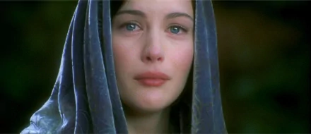 Liv Tyler as Arwen in a poignant moment from The Lord of the Rings: The Return of the King. The image captures her emotive expression, set against a soft background.