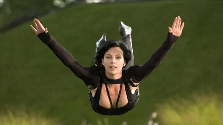 Charlize Theron as Aeon Flux in a dynamic action pose from the movie, captured in an HD desktop wallpaper background.