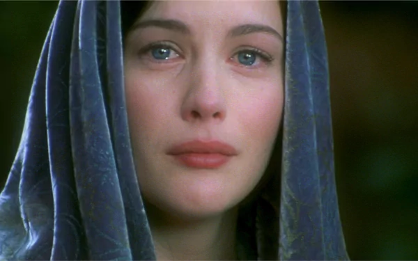 Liv Tyler as Arwen in a poignant moment from The Lord of the Rings: The Return of the King. The image captures her emotive expression, set against a soft background.