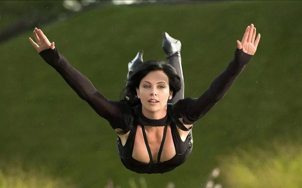 Charlize Theron as Aeon Flux in a dynamic action pose from the movie, captured in an HD desktop wallpaper background.