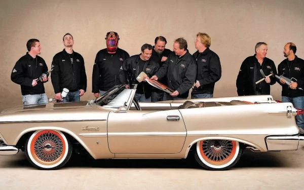 HD PC desktop wallpaper showing a beige vintage Chrysler convertible with wire wheels against a neutral backdrop, a group of men in black jackets standing and chatting behind the car.